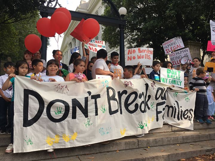 Supporters of undocumented residents march through downtown Athens with signs and banners.